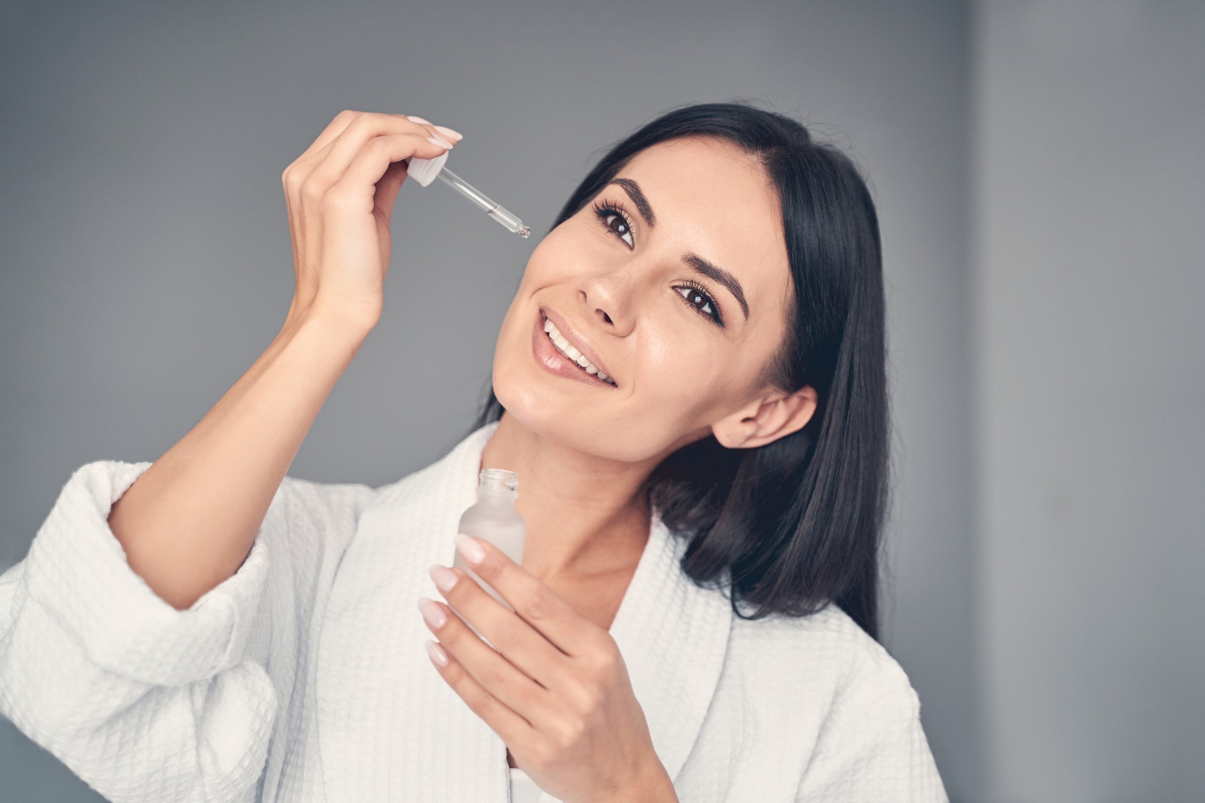 Girl applying a face serum to her skin