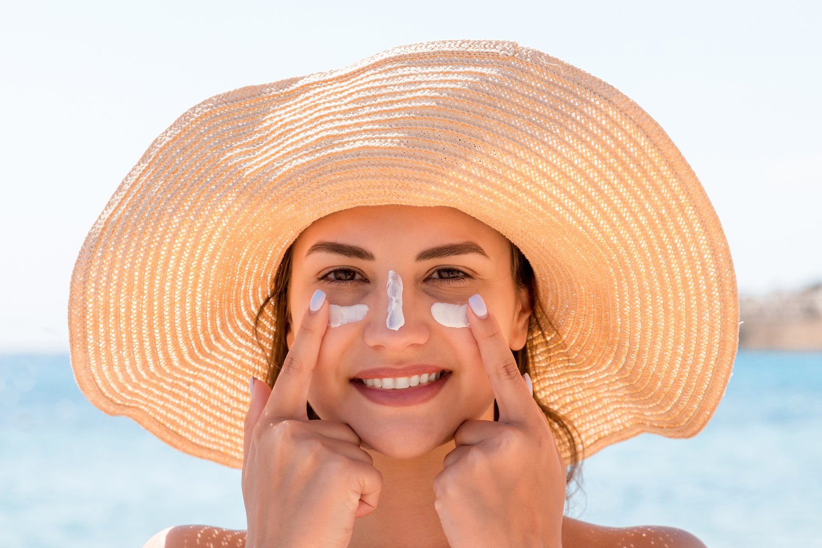 Woman Applying Sunscreen on Face 