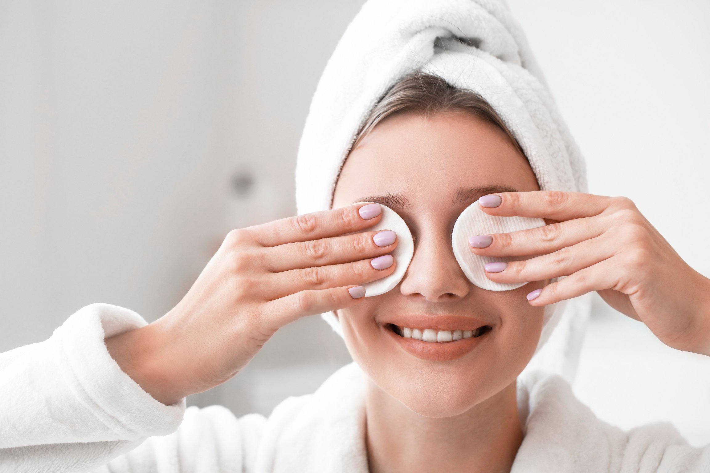 Beautiful Young Woman Removing Makeup at Home