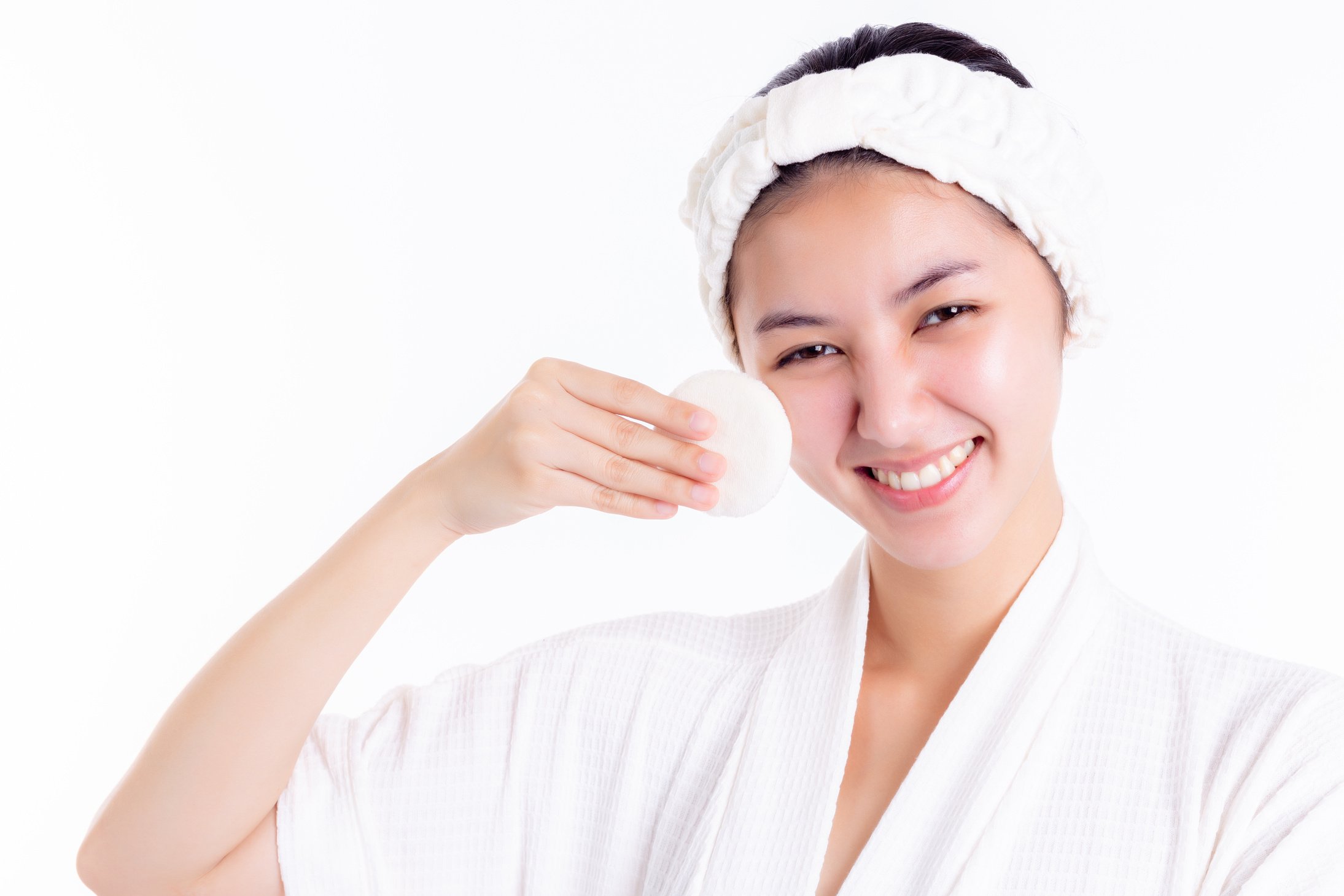 Pretty woman cleaning beautiful face by wiping, using cotton pads, cleansing lotion, facial toner. Attractive beautiful young lady has nice facial skin, bright facial skin. Facial skin care concept.